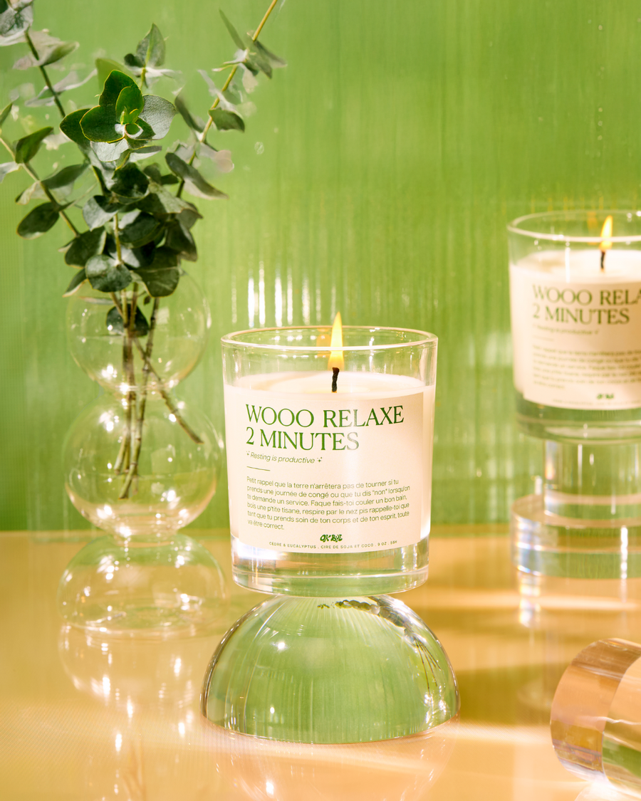 Bougie Eucalyptus & Cèdre « Wooo relaxe 2 minutes » allumée près d'un vase d'eucalyptus